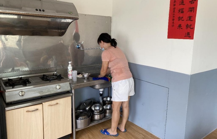 小翠右手邊是衛浴室,牆下方活動式板子,用螺絲拴緊,往後裡面管路有問題,只要拆掉板子就能維修,這是營建處陳文亮心思細膩之處。(攝影者:溫燕雪,地點:彰化縣福興鄉,日期:2021/07/19)