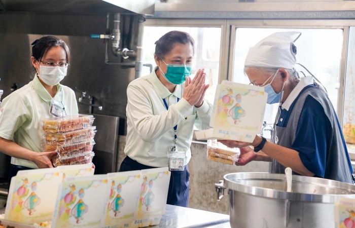 近中午時,臺中慈濟醫院副院長莊淑婷(中),無聲無息地走進大寮深怕驚擾著大家,向每位志工深深一鞠躬,並送每位志工每人一盒奶油酥條(縣餅)以表達感恩之意。(攝影者:黃嘉珍,地點:臺中心田聯絡處,日期:2021/06/01)