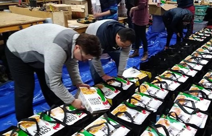 上班族志工把握因緣付出,利用晚間協助領貨、運送、打包的工作。(慈濟志工提供)