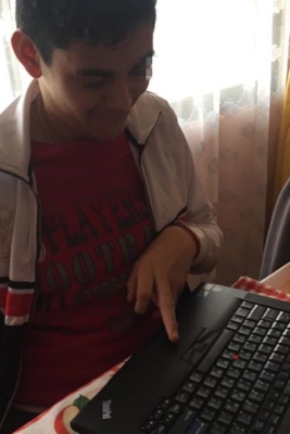 基尼女士的孫子弗朗西斯科(Francisco)輕輕撫摸電腦鍵盤,開心地不斷感謝慈濟。(慈濟志工提供)