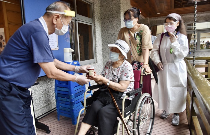 完成施打後,洪先生推著母親順著動線走出靜思堂,雖然家住附近,但這是他第一次進入靜思堂,「規劃得很好,讓人在裡面感到很安心。」(攝影者:郭明娟,地點:高雄靜思堂:日期:2021/06/19)