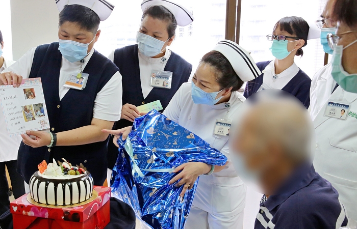 醫護同仁送上蛋糕和誠意滿滿的手寫卡片,還有一臺能固定在床上的復健踏步機,希望對病人出院後的復健計畫能有幫助。(攝影者:鍾懷諠)