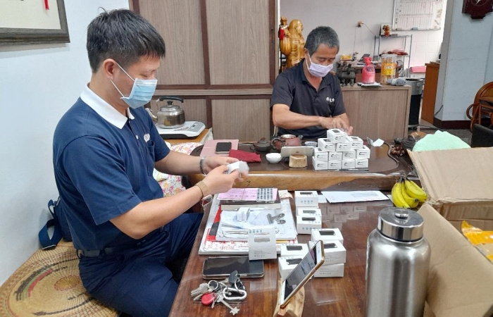慈濟志工方奇輝(左)及謝蔡福(右)把握因緣,一同為贈與法親家人的血氧機包裝及測試而努力。(攝影者:謝國榮,地點:新竹,日期:2021/07/12)
