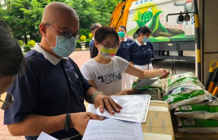 民族國小杜玫潓主任(右)已在校門口迎接,孝信師兄(左)說明生活箱的內容物並表達上人的祝福。(攝影者:汪玉秀,地點:高雄三民區,日期:2021/08/18)